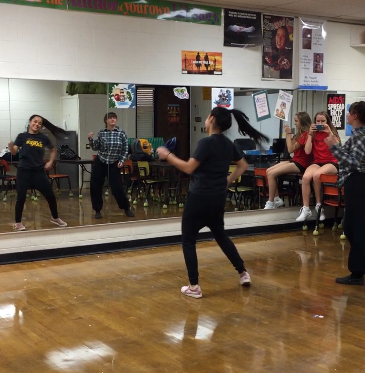 Dance club founder Isa Lyda, teaches some moves to Kaitlyn Potger while Isabella Janney films. 