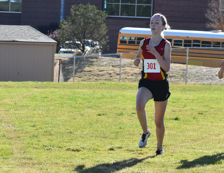 Chloe Cassens charges down the finish line for first place at the Metro League meet where she lead her team to the title, as well.