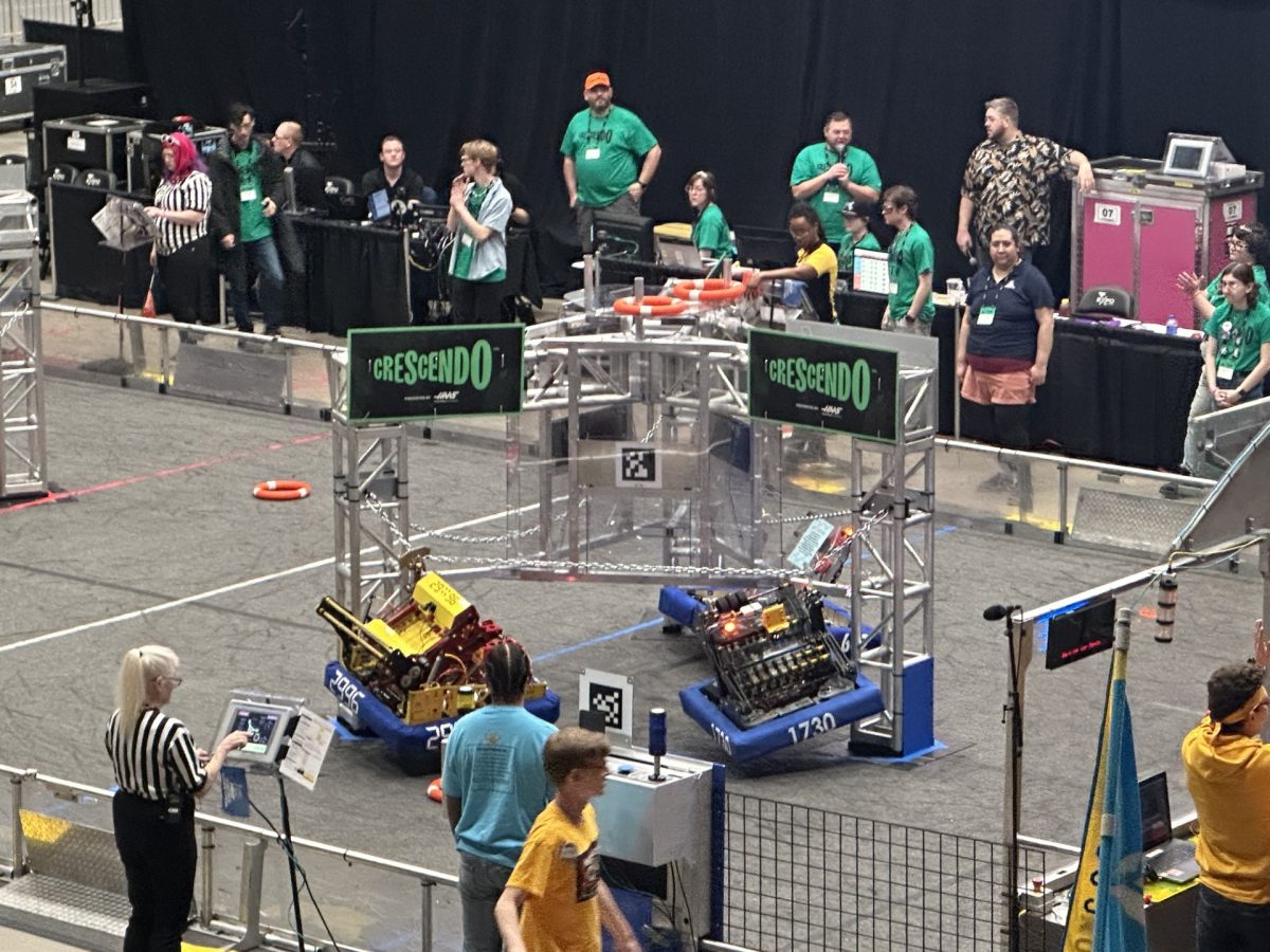 Team 2996 (yellowed-colored robot on the left) climbing the “Stage” at the Green County Regional.