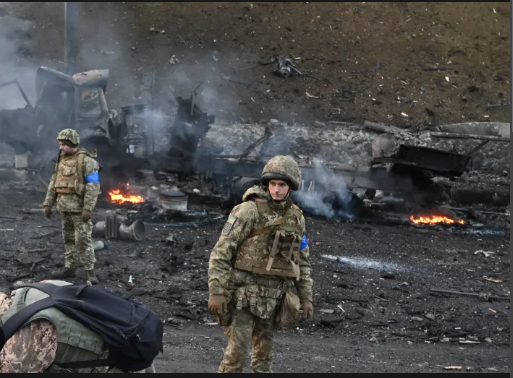 Ukrainian soldiers viewing the aftermath of a battle in their capital city, Kyiv.