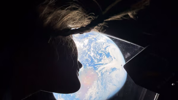 Christina Koch looking back at Earth in deep space. Photo credits to NASA