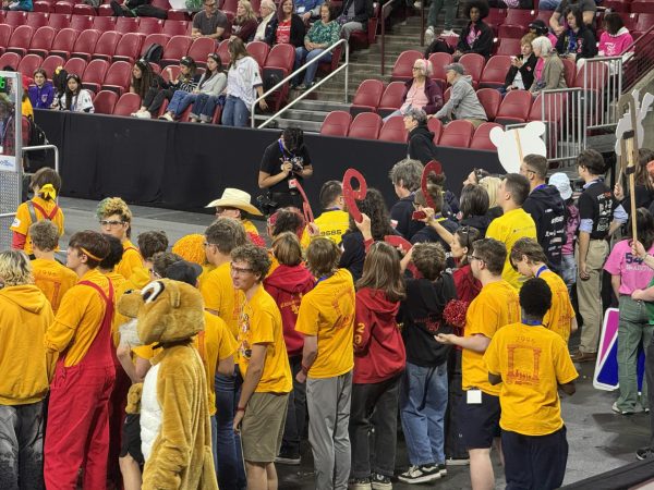 Cougars Gone Wired team members gather near the field to cheer the team on during a match.